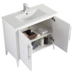 The Leafside 36 Inch Bathroom Vanity With Sink boasts an open cabinet displaying neatly arranged towels, a basket with bottles, and toiletries. Its sleek design is enhanced by the integrated sink and overhead faucet.