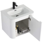 The Caskvalley 24 Inch Wall Mounted Bathroom Vanity boasts a sleek white design with a modern basin and black faucet. Its open cabinet door reveals organized toiletries, while vertical grooves enhance its contemporary style.