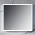 The Capella 36 inch LED Medicine Cabinet is a modern square piece featuring mirrored doors and integrated LED lights. It complements marble-patterned walls and has touch-sensitive mirror controls for easy use.