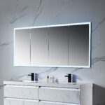 A contemporary bathroom features a double sink vanity with sleek fixtures against a gray marbled wall. Above the sinks, the Capella 72 inch LED Medicine Cabinet shines, offering a backlit four-panel mirror. A small bottle and soap dispenser are neatly arranged on the countertop.