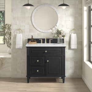 An elegant bathroom features the Lorelai 36 inch Bathroom Vanity Cabinet in Amber Birch, along with a white countertop and brass faucet. Above, a round mirror flanked by pendant lights hangs. Gold rings hold towels, while potted plants bring greenery to the cream tiled wall and hardwood floor.