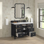 A contemporary bathroom features the Lorelai 48 inch Single Bathroom Vanity Cabinet with open drawers, a white countertop, scalloped-edge mirror, pendant lights, towel rings, and a window with a Roman shade for natural light.