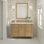 A bathroom features a Lorelai 48-inch Single Bathroom Vanity Cabinet with a white marble countertop and brass fixtures. A rectangular mirror is flanked by sconces, and floral wallpaper with pale tiles enhances the elegant atmosphere.