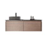 The Ocala 60 Inch Wall Mount Bathroom Vanity With Vessel Sink includes a textured wood cabinet, black countertop, rectangular vessel sink with black faucet, and two bottles on a tray beside the sink.