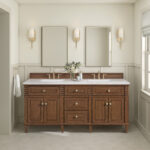 A bathroom featuring the Lorelai 72 inch Double Bathroom Vanity, two rectangular mirrors, brass fixtures, wall sconces, and a vase with flowers on the counter. Soft neutrals and a window create a bright, airy feel.