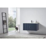 A modern bathroom with a large window, a blue Barcelona 42 Inch Wall Mount Bathroom Vanity with a black faucet, a ladder towel rack, a chair, and a light rug on concrete flooring. Trees can be seen outside.