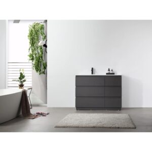 A modern minimalist bathroom features a Rothenburg 42 Inch Freestanding Bathroom Vanity, a light gray rug, a white freestanding tub, potted plants, and bright white walls illuminated by natural light.