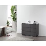 Modern bathroom with a Rothenburg 42 Inch Freestanding Bathroom Vanity, black faucet, small bottles, and light gray rug. A plant on a side table and a hanging green plant add greenery as sunlight streams through the window.