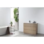 A modern minimalist bathroom featuring a Rothenburg 42 Inch Freestanding Bathroom Vanity, black faucet, white sink, rectangular bathtub, a chair with a plant, and greenery by a bright doorway.