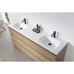 Rothenburg 72 Inch Freestanding Bathroom Vanity with light wood drawers, white countertop, two integrated sinks, and black faucets. Toiletries and soap are neatly arranged between the sinks.