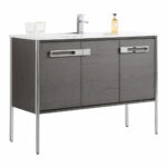 The Oakville 48 inch Modern Bathroom Vanity features a dark wood finish, metal legs, two cabinet doors with wide silver handles, a white countertop, and comes topped with a faucet, two glasses, and a soap dispenser.