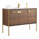 The Oakville 48 inch Modern Bathroom Vanity features a modern wood finish, gold metal legs and handles, a white countertop with integrated sink, gold faucet, two glasses, and a soap dispenser.