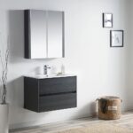 Minimalist bathroom with a Valencia 30 inch Wall Mount Vanity With Sink, mirrored cabinet above, decorative wall art, light wood floor, tall vase with twigs, and a woven laundry basket labeled laundry on the right.