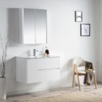 Minimalist bathroom with the Valencia 36 inch Wall Mount Vanity With Sink, a sleek mirrored cabinet, modern faucet, decorative vase with branches, towel-draped chair, and framed pictures against a crisp white wall.