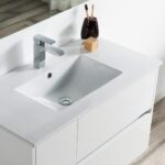 The Valencia 36 inch Wall Mount Vanity With Sink features a rectangular sink, chrome faucet, soap bar, and dark cup with toothbrushes, set against a white wall and large mirror on wood-style flooring.
