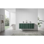 Minimalist bathroom featuring a Barcelona 60 Inch Wall Mount Double Bathroom Vanity with top in green, double sinks, and black faucets. A white tub sits near large windows overlooking greenery. A towel rack and leafy plant finish the bright, modern space.