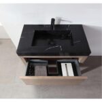 The Bibury 36 Inch Bathroom Vanity with Top features a sleek black marble sink, black faucet, and an open wooden drawer below with organized compartments holding bottles, a towel, and a rectangular box.