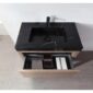 The Bibury 36 Inch Bathroom Vanity with Top features a sleek black marble sink, black faucet, and an open wooden drawer below with organized compartments holding bottles, a towel, and a rectangular box.