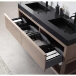 The Bibury 60 Inch Double Bathroom Vanity with Top features a modern design, black countertop, and two sinks; open wooden drawers reveal organized compartments for toiletries, towels, and bathroom essentials.