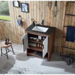 A modern bathroom with a wood-paneled wall features the Lyon 30 Inch Bathroom Vanity with Top, its open doors displaying organized toiletries and towels on shelves. Nearby sit a stool with bottles and some hanging towels.