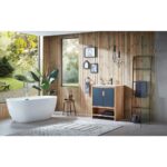 Modern bathroom with a freestanding white tub, wooden walls, the Lyon 30 Inch Bathroom Vanity with Top in blue, decorative plants, hanging lights, wall art, and a window revealing greenery bathed in sunlight.