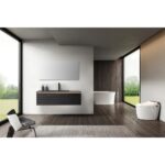Modern bathroom with large windows, an Oslo 48 Inch Wall Mount Bathroom Vanity and mirror, freestanding bathtub, white toilet, dark wood floors, chair, rug, and green outdoor scenery visible through the windows.