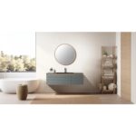 A modern bathroom featuring the Oslo 48 Inch Wall Mount Bathroom Vanity with sink, a round mirror, a woven stool, a wooden shelf stocked with towels, a round bathtub, and large windows that fill the space with natural light.