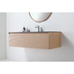 A modern Oslo 48 Inch Wall Mount Bathroom Vanity with light wood finish, two cabinet doors, dark countertop, chrome faucet, and round mirror above. Set against a white wall with a soap dispenser and cup on the counter.