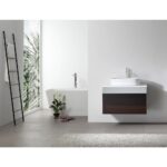 Modern minimalist bathroom with a Ronda 30 Inch Wall Mount Bathroom Vanity with vessel sink, a freestanding white tub, ladder-style towel rack, potted plant, and sunlight streaming through a window framed by leafy plants.