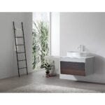 A modern bathroom features a Ronda 30 Inch Wall Mount Bathroom Vanity with vessel sink and white faucet. By the large window with greenery, a ladder-style towel rack stands on gray tile flooring with a light rug.