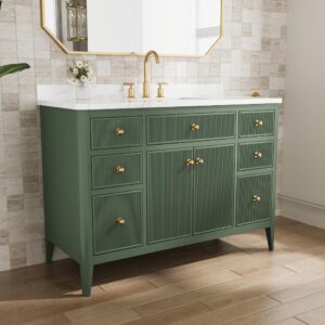 The Aveline 48 Inch Freestanding Bathroom Vanity With Top showcases a green finish, gold hardware, white marble countertop, gold faucet, and floral vase. Six drawers and two cabinets are set against a tiled wall below a large mirror.