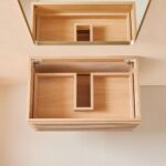 The Linea 30 Inch Wall Mounted Bathroom Vanity has a wooden wall-mounted drawer with large side compartments, a smaller center compartment, and a mirror above, all visible from the open top view.