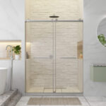 Modern bathroom featuring the Shower Door Double Sliding Frameless on a glass tub, white brick wall, overhead shower, built-in shelves with potted plants, white bathtub, circular mirror above green vanity, and a beige mat on the floor.