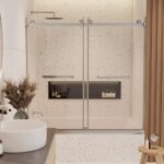 Modern bathroom with a Tub Door Double Sliding Frameless, terrazzo tile walls, built-in bathtub, black recessed shelf for toiletries, and a countertop featuring a round sink and a vase of dried flowers.