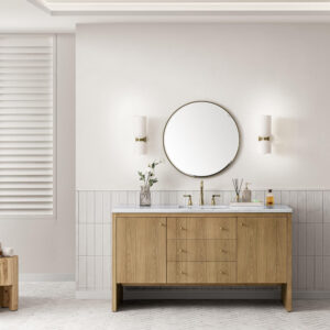 A modern bathroom with a wooden vanity, round mirror, two white wall sconces, marble countertop, and minimalist decor on the counter. The walls are light, with vertical tiles on the lower half and white blinds on the left.