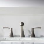 The Vermont 8 Inch Widespread Bathroom Sink Faucet in brushed nickel features two handles and a sleek, minimalist design, making it a stylish upgrade for your bathroom décor.