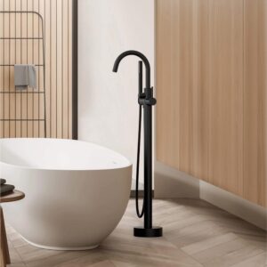 A modern bathroom with a white freestanding tub, the Halo Floor Mount Tub Filler With Hand Shower in black, light wood panel walls, and a geometric tile floor.