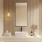 Minimalist bathroom features Metal Framed Mirrors, a square white sink, stacked towels, dried plants in a vase, soap, candle, and a hanging exposed bulb light against vertical wooden slat wall panels.