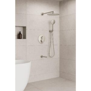 A modern bathroom with beige tiled walls showcases the Halo Pressure Balanced Wall Mount Shower System, featuring a round rainfall showerhead, handheld shower, built-in shelf with a bottle, grab bar, and white bathtub.