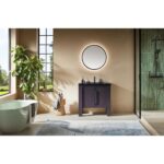 Modern bathroom featuring the Munich 36 Inch Bathroom Vanity with Top, a round backlit mirror, green plant by large windows, freestanding tub, glass shower with green tiles, and a light blue rug on the floor.