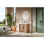 Modern bathroom featuring the Munich 36 Inch Bathroom Vanity with Top, round backlit mirror, plant by a window, freestanding bathtub, and glass-enclosed shower with green tiles. Natural light highlights the clean, minimalist decor.