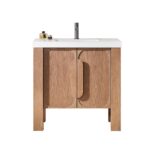 The Munich 36 Inch Bathroom Vanity with Top features a modern wood design, a white sink, two cabinet doors with large vertical handles, and a chrome faucet. Small toiletry bottles sit on the left side of the countertop.