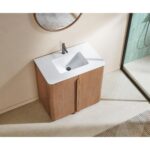 The Parma 36 Inch Bathroom Vanity With Top includes a white rectangular sink, wooden cabinet, single faucet, round mirror above, beige floor beneath, and a glass shower enclosure visible to the right.
