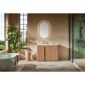 Modern bathroom with a green bathtub, Parma 48 Inch Bathroom Vanity With Top, oval backlit mirror, indoor plant, and glass shower. Large windows bring in natural light, and neutral tones with minimal decor create a serene vibe.