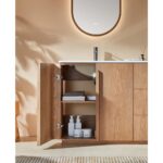 A modern Parma 48 Inch Bathroom Vanity With Top features light wood cabinets. The left door is open, revealing neatly folded towels and bottles inside. Above is a white sink with a black faucet and an oval mirror on the wall.
