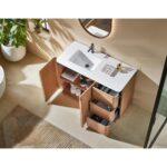 The Parma 48 Inch Bathroom Vanity With Top has a white sink, wooden cabinets, and open drawers showing toiletries and towels. A round mirror hangs above it, while a plant and striped rug decorate the nearby beige floor.
