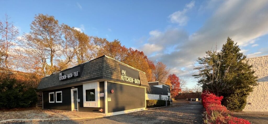 Anve Kitchen And Bath Anve Kitchen And Bath Showroom building surrounded by autumn trees with colorful leaves, it hints at expert kitchen design as bright sunlight casts long shadows across the vibrant scene.