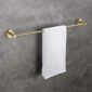 A white towel hangs neatly on a gold-colored towel bar mounted on a gray, textured wall.