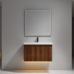 The Lille Wall Mounted Bathroom Vanity features a wood finish, white sink, black faucet, and a large square mirror, plus soft under-cabinet lighting, all set against a gray wall for a modern touch.