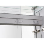 A close-up of the Royale 15 inch ×70 inch Side Tall Medicine Cabinet featuring a safety pin on a hook, two glass shelves above, power outlets on the right, and metal hinges on the door.